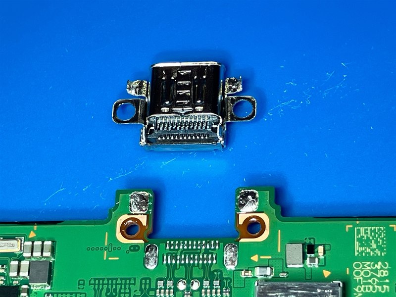 Replacement USB-C charge port prepared for a Nintendo Switch board